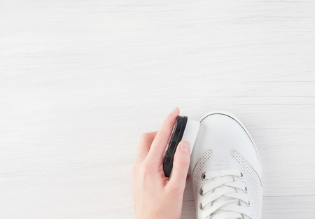 Care for leather shoes over white wooden background. The background image place for text.
