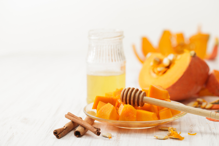 Cut the white pumpkin on the kitchen table. The recipes for the pumpkin with honey and cinnamon. Place for text.の写真素材