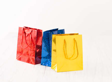 Three color gift package on a white wooden background. View with copy space