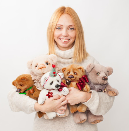 The girl holds in hands of toy bears and smiles. Homemade soft toys with their hands.の写真素材