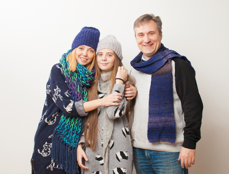 Family in warm clothes on white background. Have fun.の写真素材