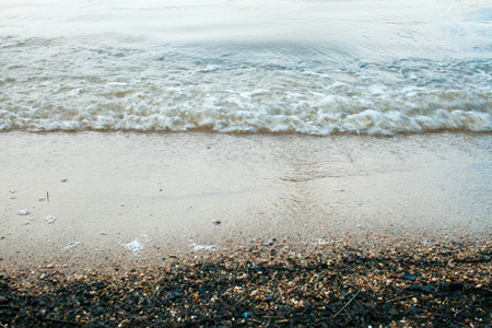 Waves on the sandy beach of the lake before the rain. Background image. Vintage effect.の写真素材