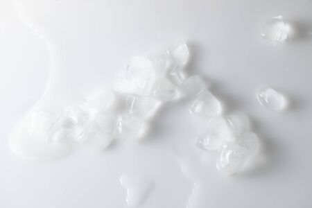 Background image of melting ice with water streaks on a white glossy background. The concept of...