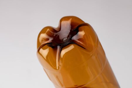 Petal bottom of a brown plastic bottle on a whiteの写真素材
