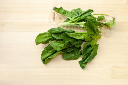 Fresh spinach: marsh grass, patience dock leaves on a wooden background