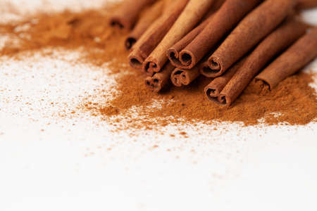 Background image macro cinnamon sticks with ground cinnamon on a white backgroundの写真素材