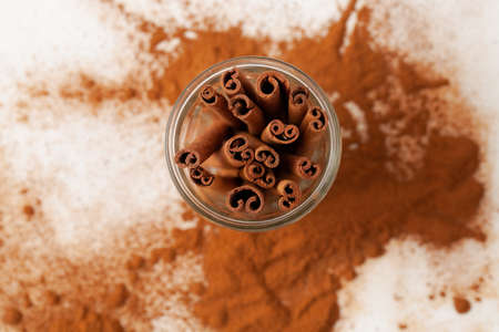 Cinnamon sticks in a glass top view on a white background in the recipes of cosmetics and cooking, folk medicineの写真素材