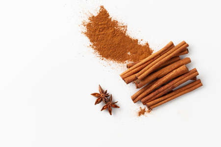 Top view of cinnamon sticks and ground cinnamon on a white background in recipes cooking and folk medicineの写真素材