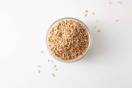 Oat grains cereals pile in a bowl top view surface close up isolated on a white background. Copy...