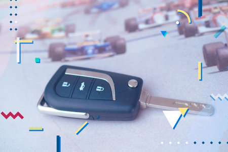Car keys with remote control, racing cars in the backgroundの写真素材