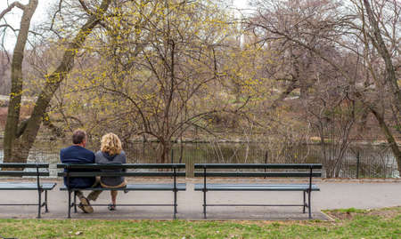Man and Woman sitting on a bench in Central Park, New York Cityの写真素材