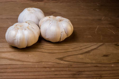 Garlic cloves on a wood surface ready to be chopped and cookedの写真素材