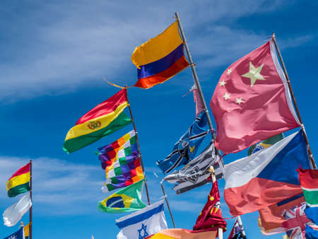 Flags from multiple nations waving against a blue skyの写真素材