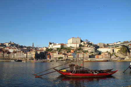 boat on the douro river with views of the city of porto
