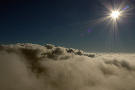 Aerial photo above the clouds with the view to the sunの写真素材