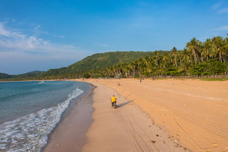 Motorcyclist driving on the tropical Nacpan beach in the Philippinesの写真素材