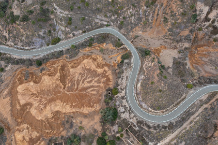 Aerial view of a beautiful S-shaped road of an abandoned mine in a desert area in La Union, Murcia.