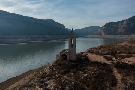 Aerial view of the Sau reservoir in drought, with the Romanesque tower of Sant Roma, Vilanova de Sau.の写真素材