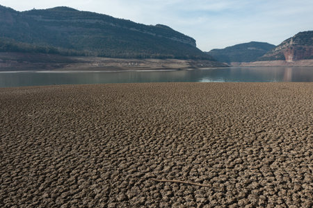 Aerial view dry and cracked earth in the reservoir at Sau reservoir, Cataloniaの写真素材