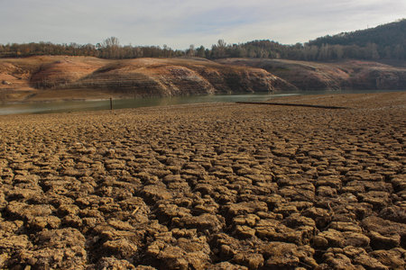 Aerial view dry and cracked earth in the reservoir at Sau reservoir, Cataloniaの写真素材