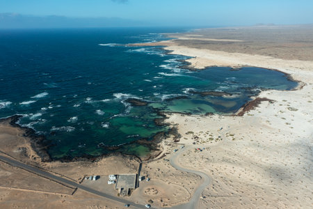 A breathtaking aerial photograph of the natural volcanic pools at Los Charcos Beach, located on the...