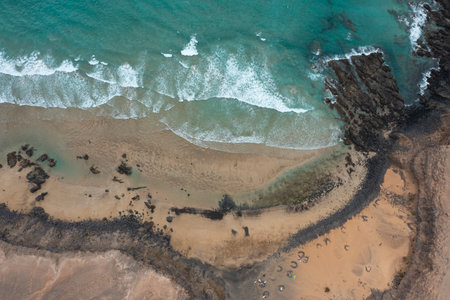 A dramatic aerial photograph capturing the wild beauty of Esquinzo Beach on Fuerteventura, one of...