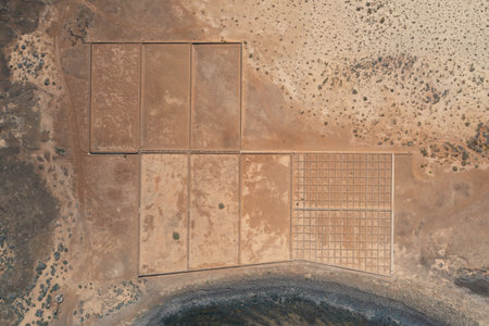 Stunning aerial photograph of the Salinas de Lobos, the traditional salt flats of Lobos Island in the Canary Islands, surrounded by volcanic landscapes and the turquoise waters of the Atlantic Ocean.の写真素材