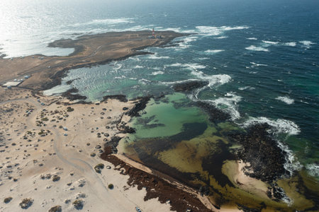 Panoramic overhead view of rugged volcanic terrain and natural rock windbreaks by the Atlantic Ocean.の写真素材