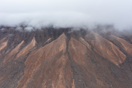 Stunning panoramic landscape of JandÃ­a Mountains rising in the background and partially covered by soft clouds. A wild, remote paradise of natural beauty in the Canary Islands.の写真素材