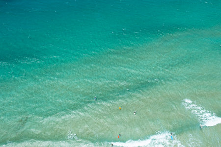 Scenic aerial panorama of Fuerteventura's Playa del Castillo, highlighting dynamic kitesurfing activity against a backdrop of crystal-clear Atlantic watersの写真素材