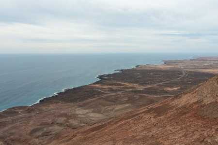 Aerial drone footage of the narrow ridge leading to the peak of MontaÃ±a Roja in Fuerteventura,...