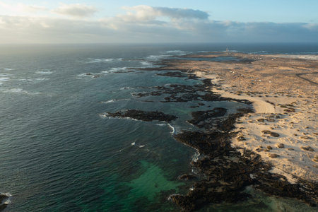 High-angle aerial view of El Islote Beach, Fuerteventura, Canary Islands, during golden hour. Unique...