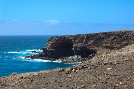 Scenic coastal path leading to the Ajuy Caves in Fuerteventura, Canary Islands. Volcanic landscape with dramatic cliffs, lava rock formations, and views of the Atlantic Ocean, ideal for travel and nature concepts.の写真素材