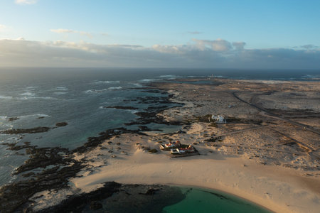 Drone aerial view of La Concha Beach at sunset in El Cotillo, Fuerteventura. Calm turquoise waters, golden sand, and warm evening light along the Atlantic coast of the Canary Islands.の写真素材