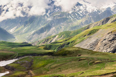 Trekking, tourism, activity in the mountains. Backpackers hiking in the mountains, early summer...