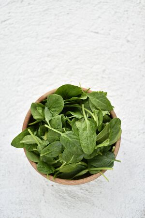 wooden bowl full of baby spinachの写真素材
