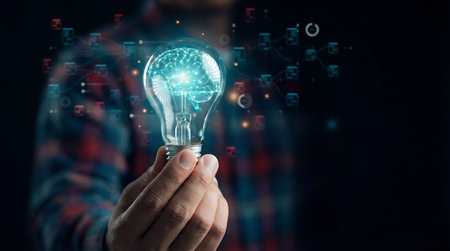 Close up of man holding light bulb with world map on dark backgroundの素材