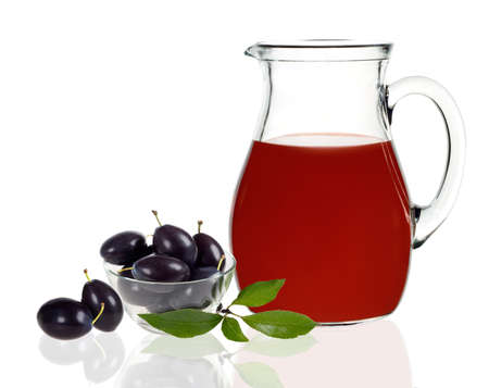 plum juice in a carafe with plums on a white backgroundの写真素材