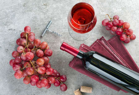 Wine bottle, wine glass, grapes and corkscrew on gray textured background. Top view.の写真素材
