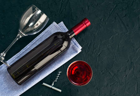 Wine bottle, wine glasses, corks and corkscrew on dark background.  Top view, copy-space.の写真素材