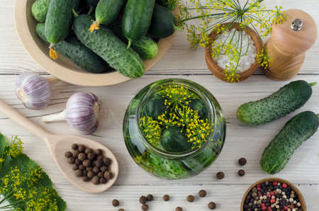 Ripe cucumbers in glass jar, spices and herbs for the pickling process. Flat lay. Top view. Ð¡lose-up.の写真素材