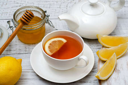 Healthy tea with lemon and honey on white wooden background. Ð¡lose-up.の写真素材