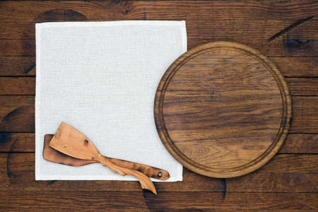 White cloth napkin and kitchen attributes on old wood table in rustic style with copy space for your...