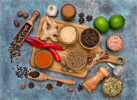 Colorful fragrant spices for cooking on wooden kitchen board and lime. Top view. Flat lay.の写真素材