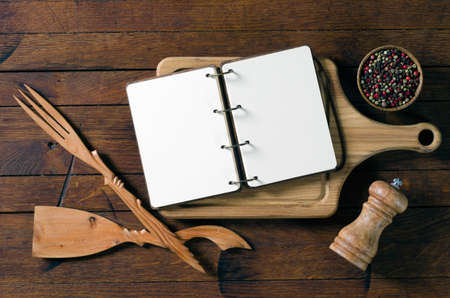Wooden kitchen utensils and recipe notebook on old wood table in rustic style with copy space for your text. Top view.の写真素材