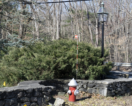 Fire hydrant with lamp and stone wallの写真素材