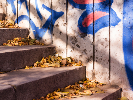 Detail of graffiti on the wall of the old building. Grungy concrete surface with cracks, scratches and streaks of paint. のeditorial素材