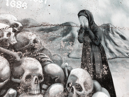 VARNA - November 11: Detail of graffiti on the wall of a woman cries near the pile of skulls. Grungy concrete surface with cracks, scratches and streaks of paint. November 11, 2015 in Varna, Bulgariaのeditorial素材