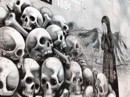 VARNA - November 11: Detail of graffiti on the wall of a woman cries near the pile of skulls. Grungy concrete surface with cracks, scratches and streaks of paint. November 11, 2015 in Varna, Bulgariaのeditorial素材