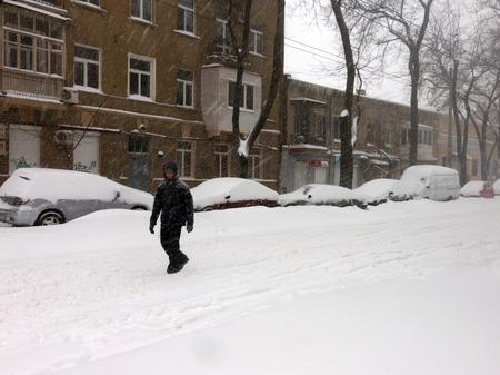 ODESSA - January 18, 2016: On snow-covered street. People go along the street during a snowfall. January 18, 2016 in Odessa, Ukraineのeditorial素材
